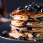 Whole Wheat Blueberry Pancakes Drizzled with Maple Syrup